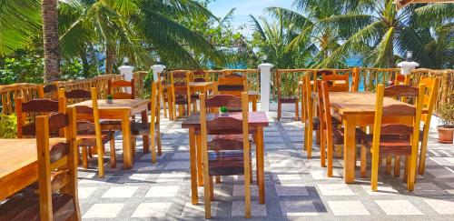 
a dining area with tables, chairs and umbrellas at DiveGurus Boracay Beach Resort in Boracay
