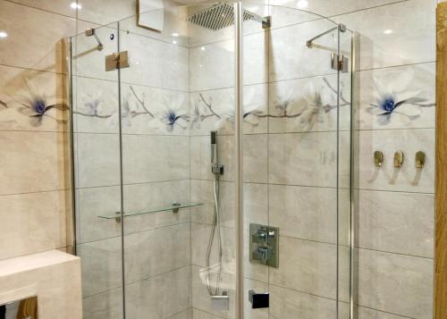 baño con ducha y puerta de cristal en Przytulny Apartament w Gołdapi, en Gołdap