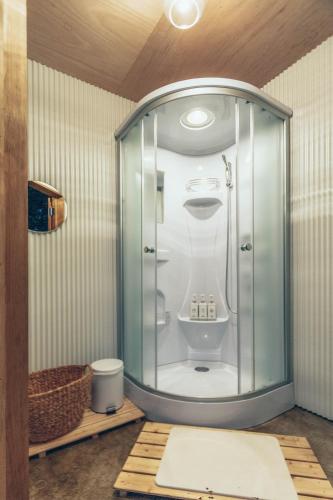 a bathroom with a toilet in a glass enclosure at Retreat Camp Mahoroba in Fujikawaguchiko