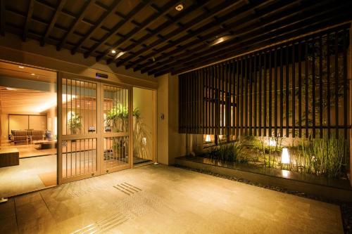 an entrance to a building with a patio with plants at Umino Ryotei Okinawa Nakamasou in Onna
