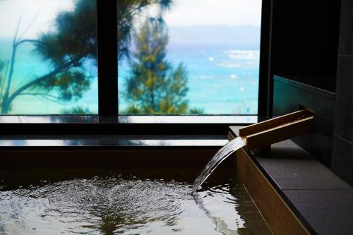 a water fountain in a room with a window at Umino Ryotei Okinawa Nakamasou in Onna