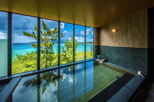 a swimming pool with a view of the ocean at Umino Ryotei Okinawa Nakamasou in Onna