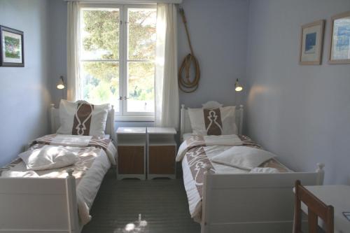 two beds in a room with a window at Furulund Pensjonat in Ron