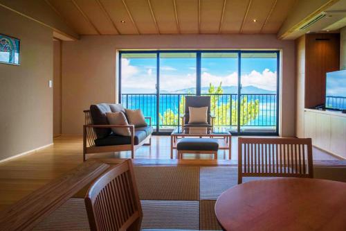 a living room with a large window with a view at Umino Ryotei Okinawa Nakamasou in Onna
