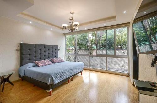 1 dormitorio con cama y ventana grande en Coyoacan Florida Luxury apartment 4BR-4BA 2Parking, en Ciudad de México