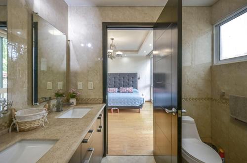 1 dormitorio con 1 cama y baño con 2 lavabos. en Coyoacan Florida Luxury apartment 4BR-4BA 2Parking, en Ciudad de México
