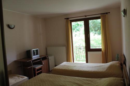 una camera d'albergo con due letti e una finestra di By the River Hotel Complex a Balkanets