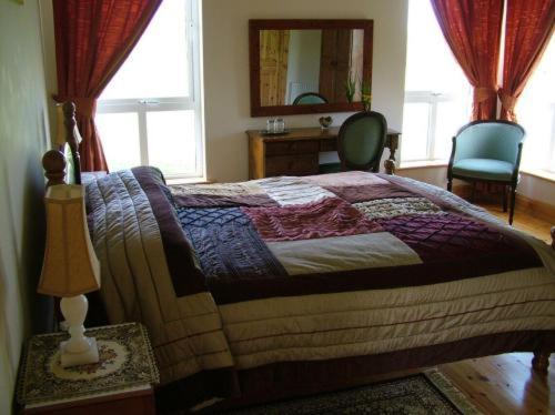 a bedroom with a bed and a desk and a mirror at Burren View B&B in Ballyvaughan