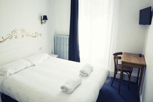 a bedroom with a bed and a table and a chair at The Old Hotel Ravel Centre in Clermont-Ferrand
