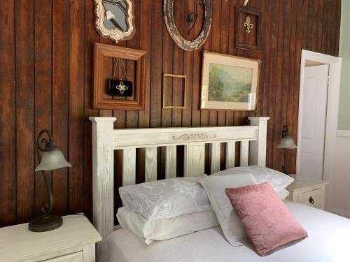 a bedroom with a white bed and wooden walls at Hillview Cottages in Kingaroy