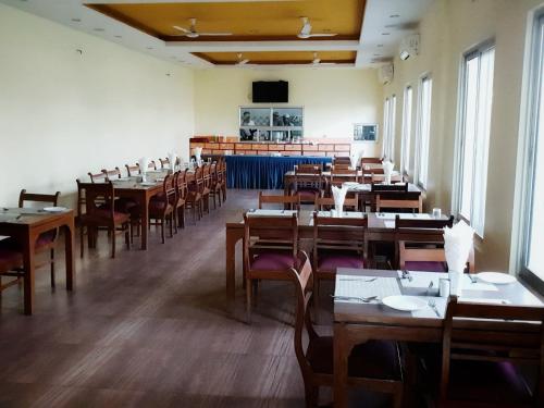 une salle avec des tables et des chaises dans un restaurant dans l'établissement Hotel The White Lotus View Pvt Ltd, à Siddharthanagar