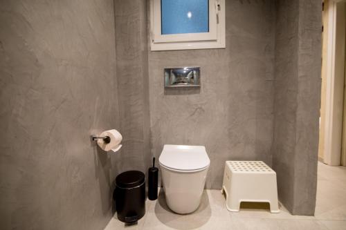a bathroom with a white toilet and a window at ThessCityLiving in Thessaloniki