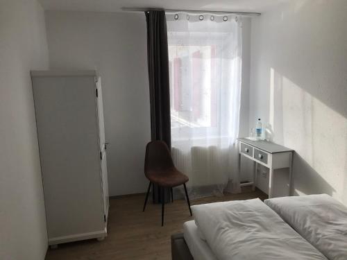 een slaapkamer met een bed, een bureau en een stoel bij Gasthof Bräuhäusle in Baienfurt