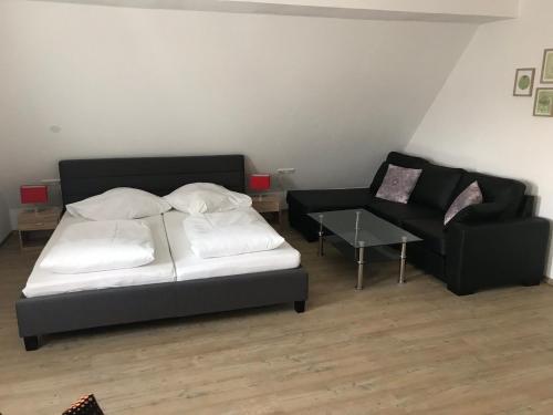 een slaapkamer met een bed, een bank en een stoel bij Gasthof Bräuhäusle in Baienfurt