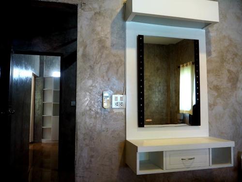 a bathroom with a mirror on a wall at NawiengkaeRiverview Resort in Mukdahan