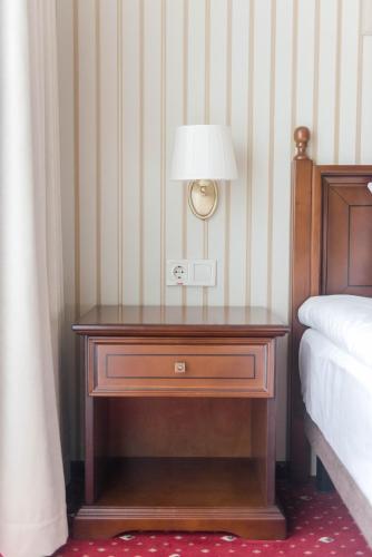 a nightstand with a lamp on it next to a bed at FENIX TOWN in Vinnytsya