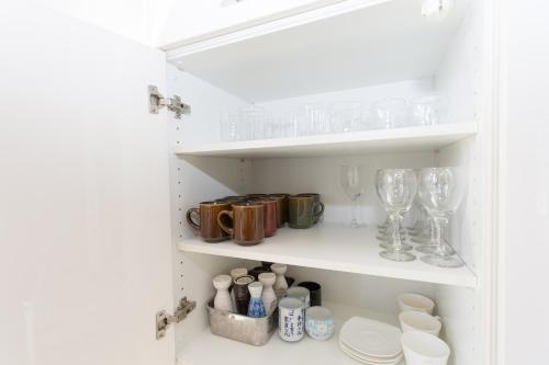 a cupboard filled with wine glasses and dishes at 暖炉之宿 コンセプトハウス星田 in Katano