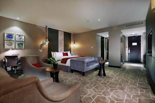 a hotel room with a bed and a couch at ASTON Priority Simatupang Hotel and Conference Center in Jakarta