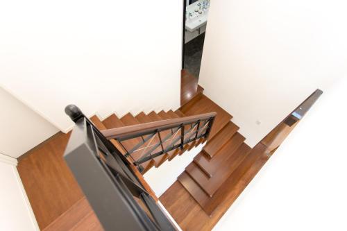 a staircase in a house with a wooden railing at 暖炉之宿 コンセプトハウス星田 in Katano