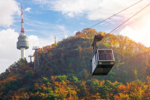 a cable car with a tower in the background at Hotel Nafore in Seoul
