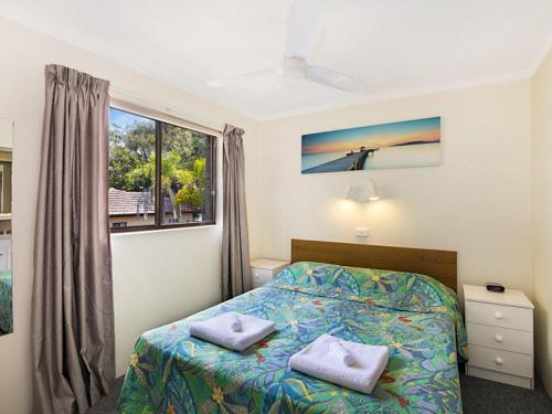 a bedroom with a bed with two pillows on it at Allamanda 37 in Long Jetty