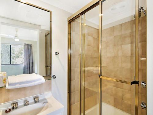 a bathroom with a shower and a sink at Allamanda 37 in Long Jetty