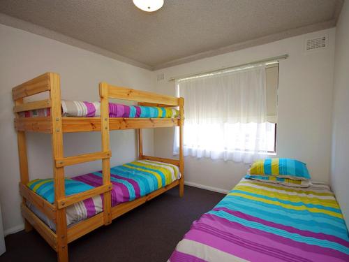 a bedroom with two bunk beds and a window at Avilla Court 1 in The Entrance