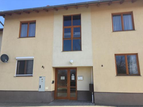 a building with a door and several windows at Orchidea Apartman in Hegykő