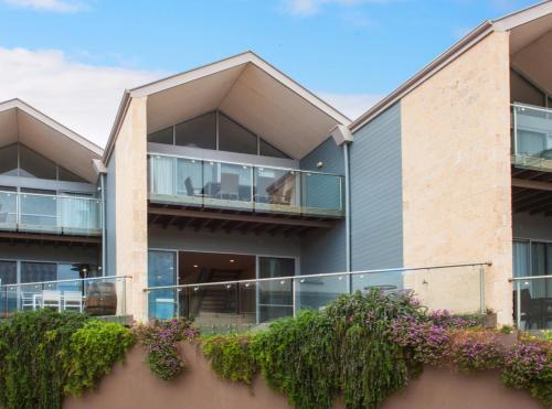 an apartment building with a balcony and plants at 16 Seine Bay Apartment in Augusta