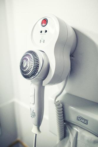 a hairdryer and a hair dryer next to a monitor at The Old Hotel Ravel Centre in Clermont-Ferrand