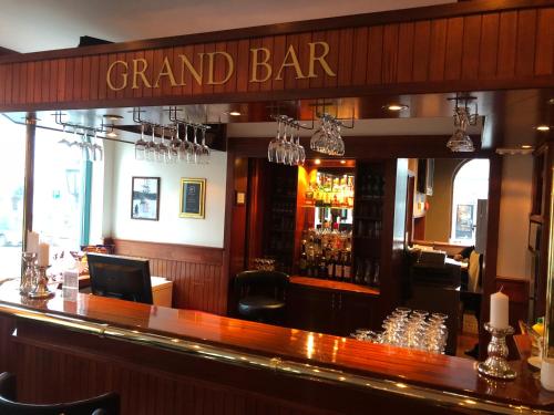 a bar with a sign that reads grand bar at Grand Hotel Arendal - Unike Hoteller in Arendal