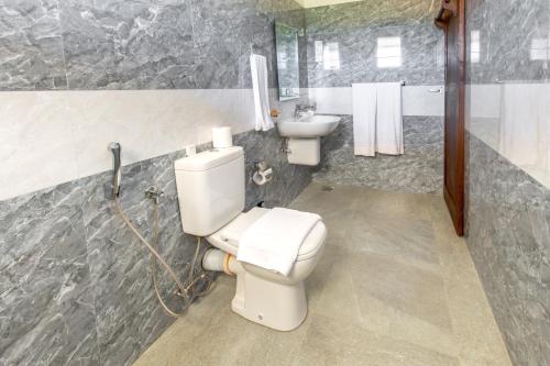 La salle de bains est pourvue de toilettes et d'un lavabo. dans l'établissement Sense Pavillion, à Horana