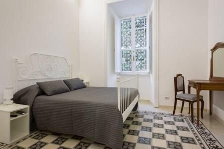 a bedroom with a bed and a desk and a window at B&B Domus Aurea in Rome