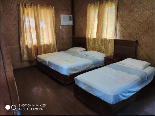 2 letti in una camera d'albergo con 2 letti sidx sidx di Marianne Port Barton a San Vicente