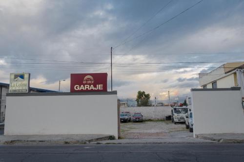 a parking lot with cars parked in front of a garage at Hotel El Altar in Riobamba