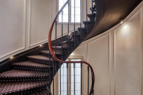 a spiral staircase in a home with a stair case at Chalgrin Boutique Hotel in Paris