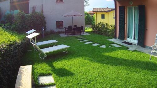 a yard with a bench and an umbrella at Orchidea Apartment in Bellagio