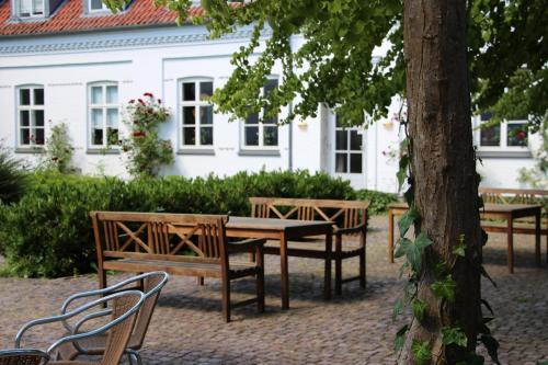 a picnic table and benches in front of a house at Tune Kursuscenter in Greve