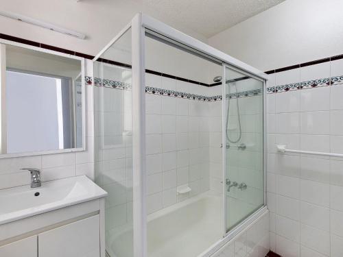a white bathroom with a shower and a sink at Dolphin Court 4 in The Entrance