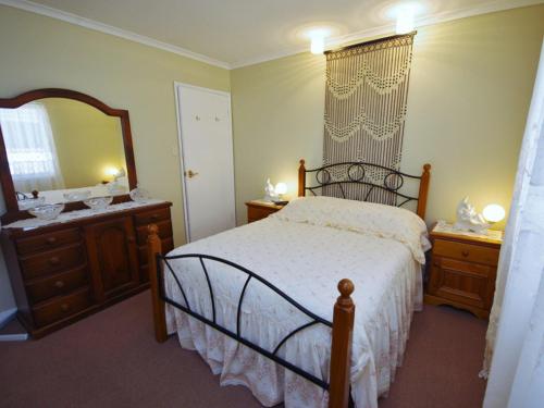 a bedroom with a bed and a dresser and a mirror at Fravent house in Toukley