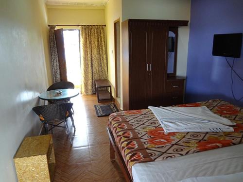 um quarto de hotel com uma cama e uma mesa e uma mesa em Stay at Tito's Lane em Marmagao