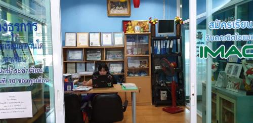 a woman sitting at a desk with a laptop at Khaohom House in Chiang Mai