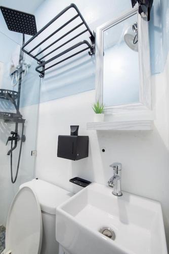 a bathroom with a sink and a toilet and a mirror at Mein Haus B @Bangsaen in Ban Rong Khoei