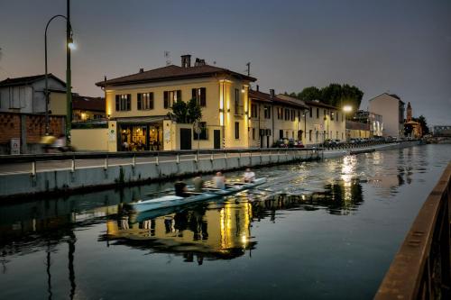 two people in a boat on a river at night at VERSOVERDE HOTEL Alzaia Naviglio Grande in Milan