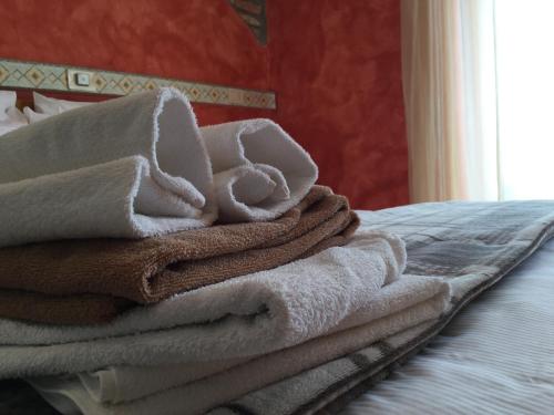 a pile of towels sitting on top of a bed at Albergo Ristorante Leso in Bosco Chiesanuova