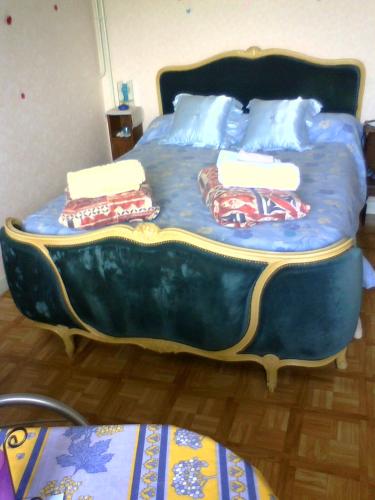 a blue bed with two pillows on top of it at Chambre de la baronne de Rochegrosse in Saint-Maurice-en-Gourgois