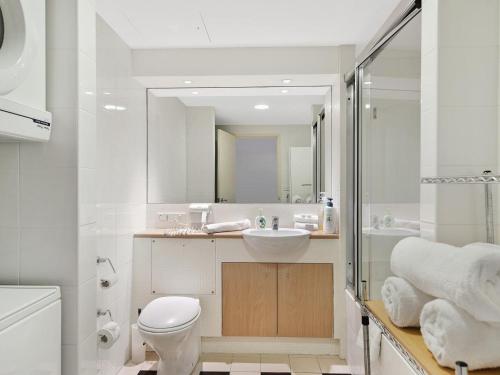 y baño con aseo, lavabo y espejo. en Waterfront Apartment 521, en The Entrance