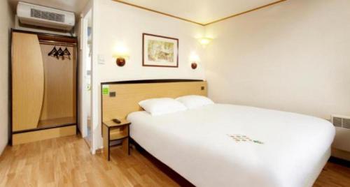 ein Schlafzimmer mit einem großen weißen Bett in einem Zimmer in der Unterkunft Campanile Moulins Avermes in Avermes