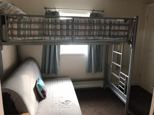 ein Schlafzimmer mit einem Etagenbett und einem Sofa in der Unterkunft Golden Sands in Portrush