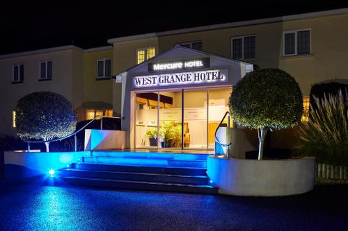 a Westtgate Garage Hotel in der Nacht mit blauen Lichtern in der Unterkunft Mercure Newbury West Grange Hotel in Thatcham